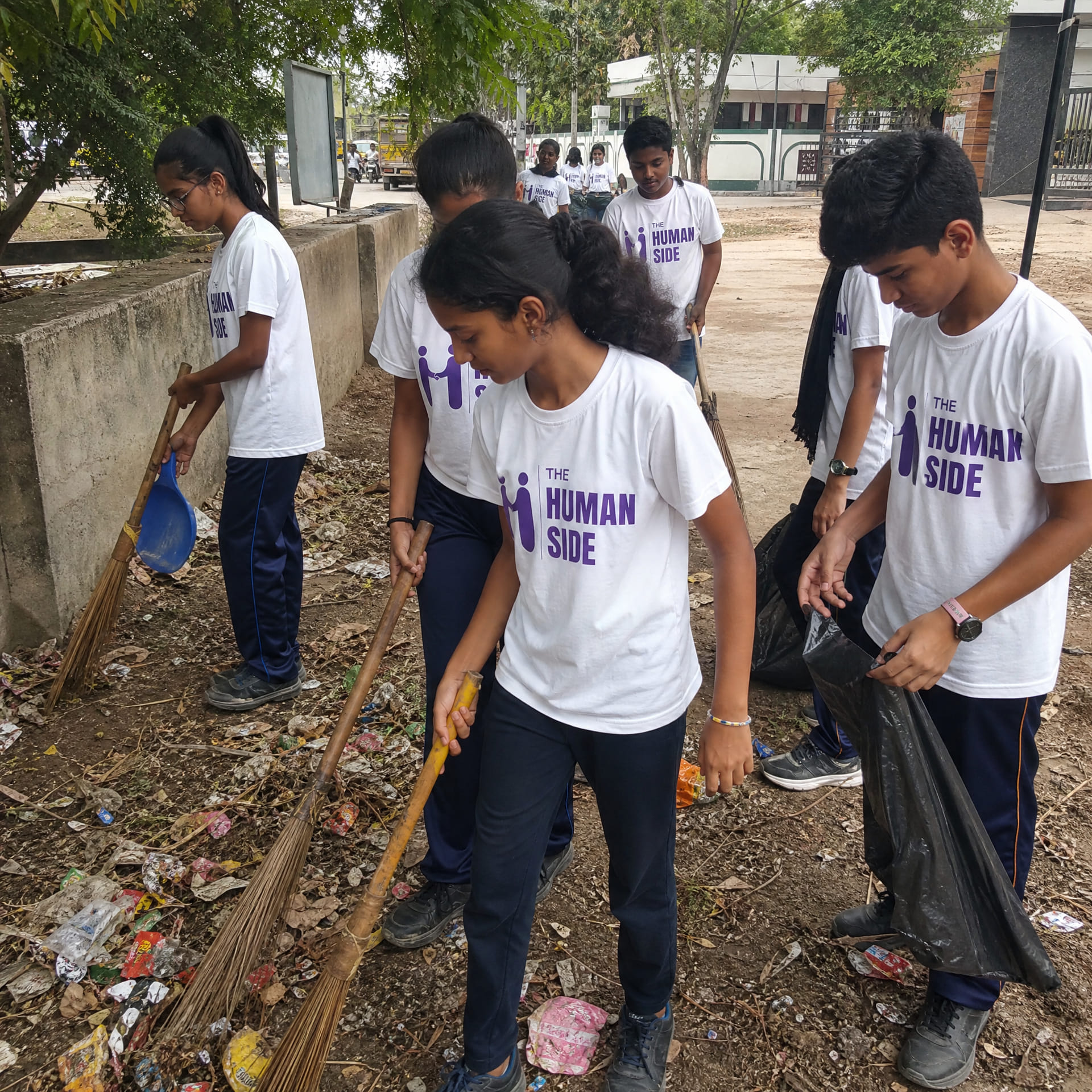 Students clearing litter from a roadside during a clean-up drive